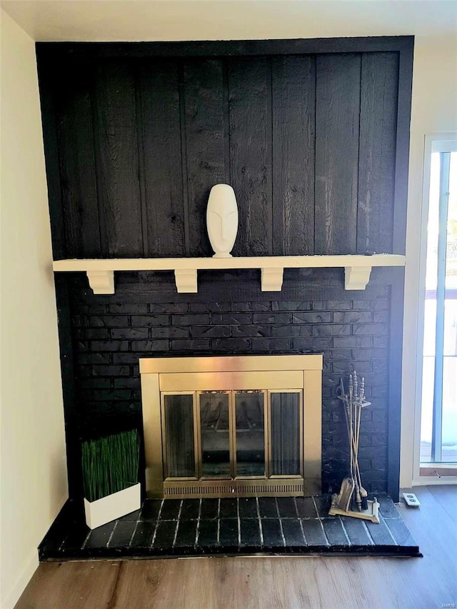 details featuring hardwood / wood-style floors and a brick fireplace