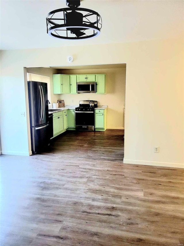 kitchen featuring hardwood / wood-style flooring, green cabinets, and black appliances