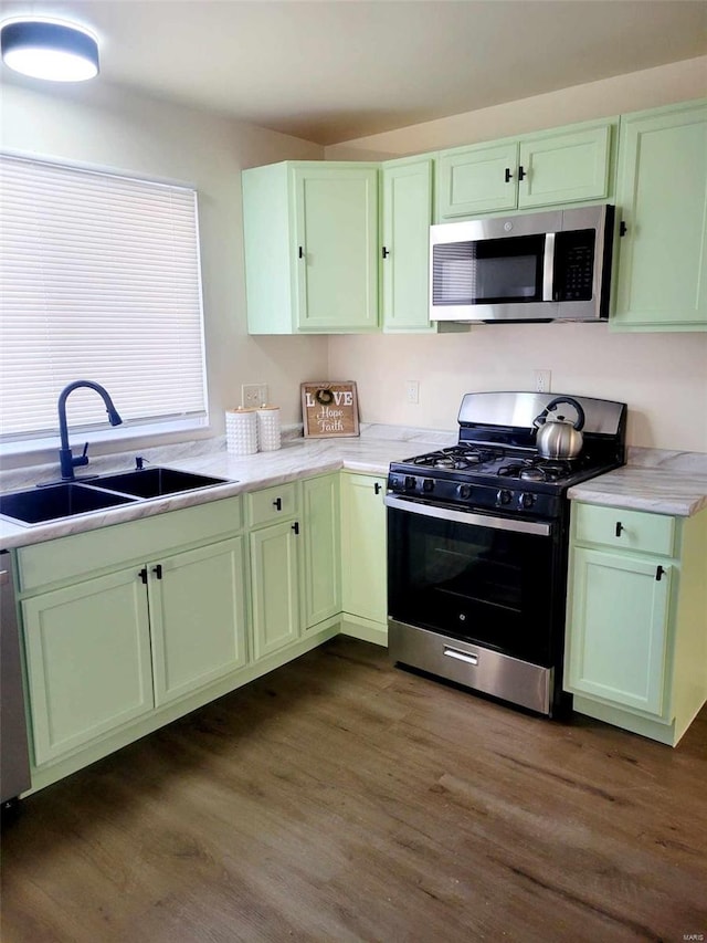 kitchen with sink, dark wood-type flooring, stainless steel appliances, and green cabinets