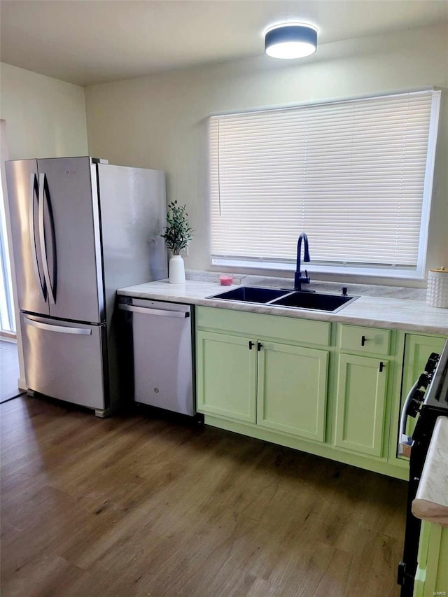 kitchen featuring green cabinets, appliances with stainless steel finishes, dark hardwood / wood-style flooring, and sink