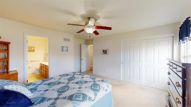 bedroom featuring ceiling fan, ensuite bathroom, a closet, and light carpet