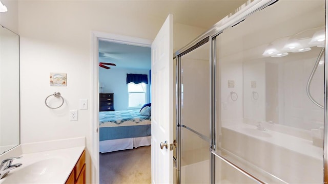 bathroom featuring ceiling fan, a shower with shower door, and vanity