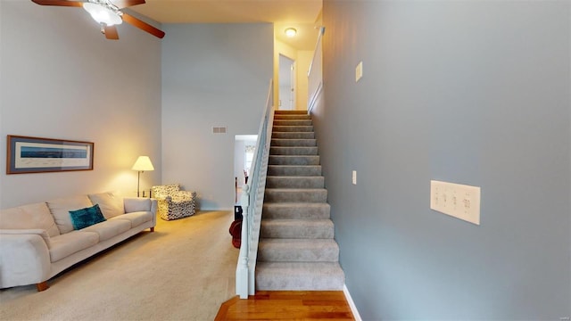 stairway featuring ceiling fan