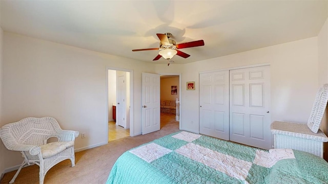 bedroom with light colored carpet, ceiling fan, and a closet