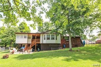 rear view of property featuring a lawn