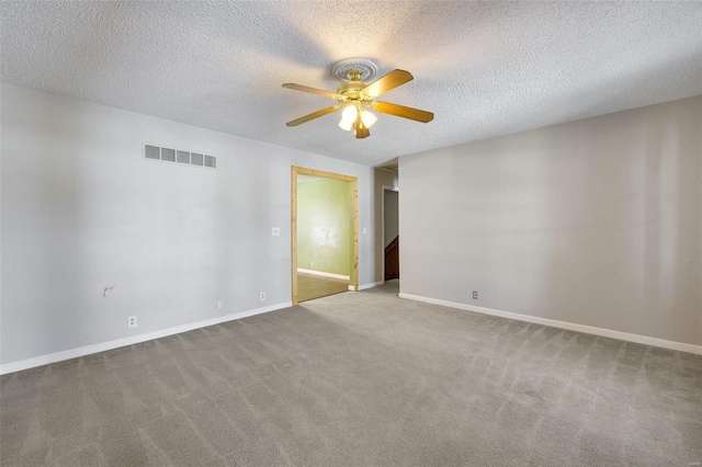 unfurnished room featuring ceiling fan, light colored carpet, and a textured ceiling