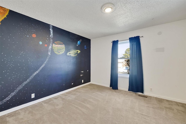 carpeted spare room with a textured ceiling