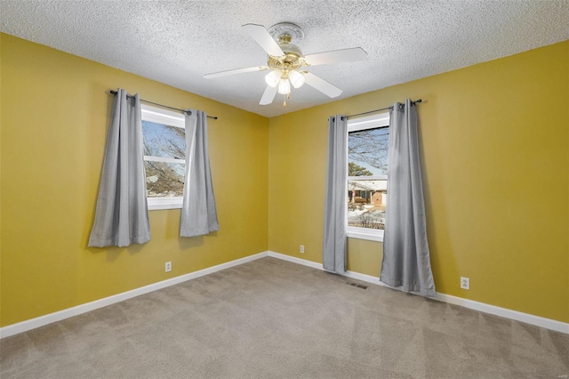 spare room with light carpet, ceiling fan, and a textured ceiling