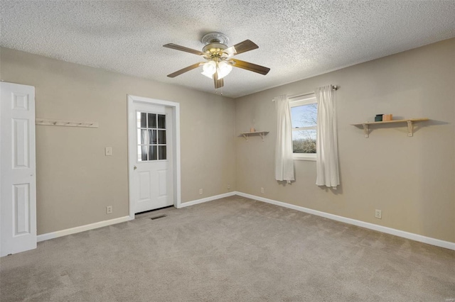 carpeted empty room featuring a textured ceiling and ceiling fan