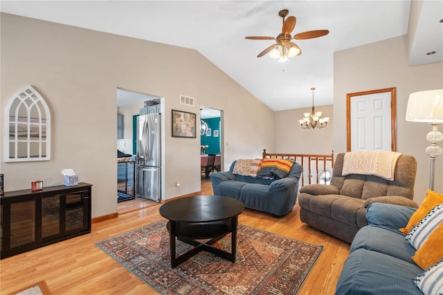 living room featuring vaulted ceiling, ceiling fan with notable chandelier, and hardwood / wood-style floors