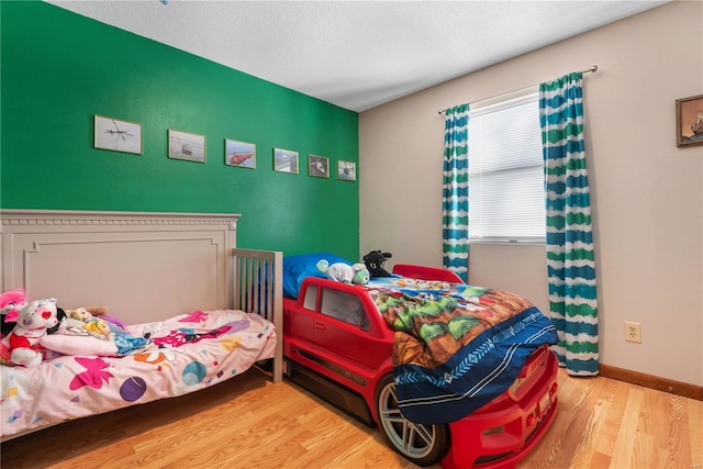 bedroom with hardwood / wood-style floors and a textured ceiling