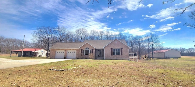 view of front facade featuring a front yard, brick siding, driveway, and an attached garage