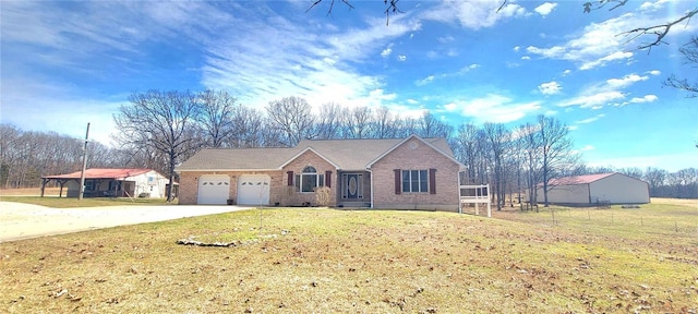 view of front of house featuring an attached garage, brick siding, concrete driveway, and a front yard