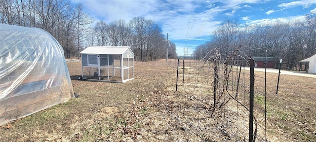 view of yard with fence, exterior structure, and an outdoor structure