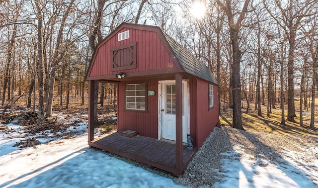 snow covered structure featuring an outbuilding