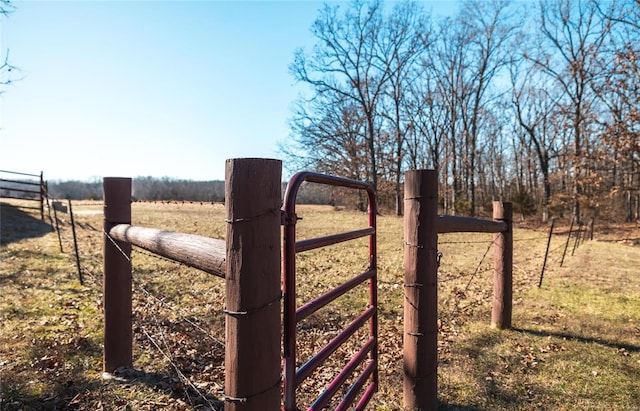 view of gate featuring a rural view and fence