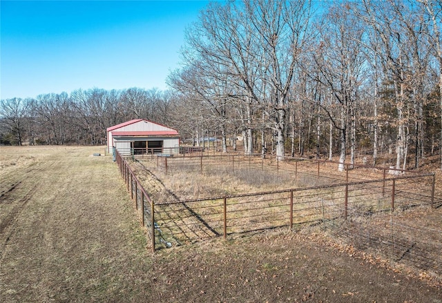 view of yard featuring an outbuilding, a pole building, a rural view, and fence