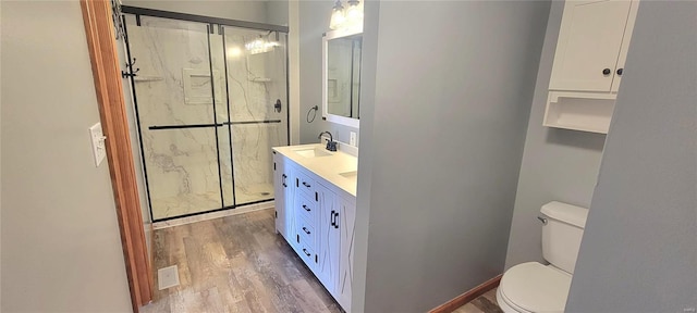 full bath with visible vents, toilet, vanity, a shower stall, and wood finished floors