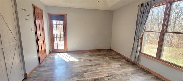 unfurnished room with light wood-style floors, visible vents, and baseboards