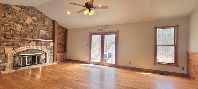 unfurnished living room featuring a fireplace, wood finished floors, visible vents, baseboards, and vaulted ceiling