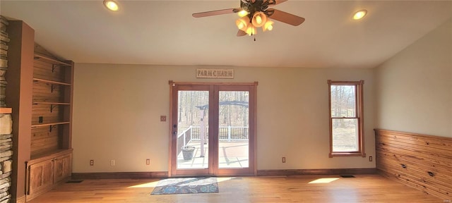 entryway with lofted ceiling, light wood-type flooring, visible vents, and baseboards