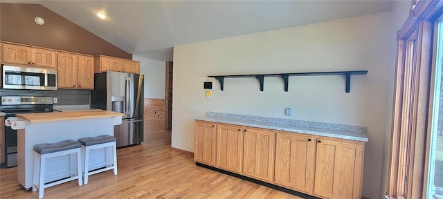 kitchen featuring lofted ceiling, appliances with stainless steel finishes, light wood-type flooring, decorative backsplash, and open shelves