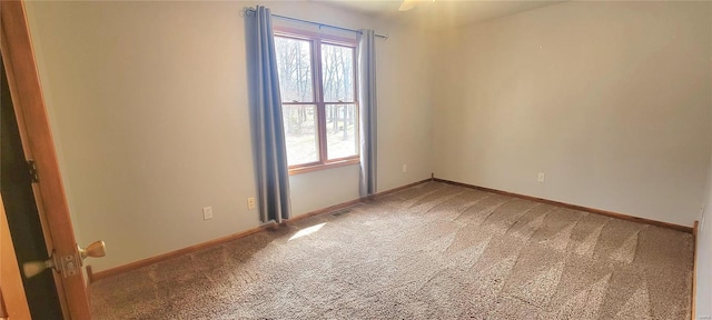 carpeted spare room featuring visible vents and baseboards