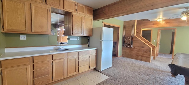 kitchen featuring a ceiling fan, light colored carpet, freestanding refrigerator, light countertops, and a sink