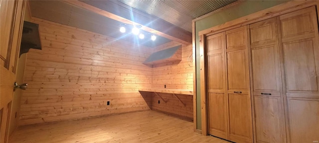 interior space with beamed ceiling, wooden walls, and wood finished floors