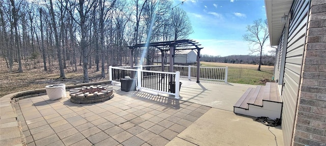 view of patio / terrace with an outdoor fire pit and a pergola