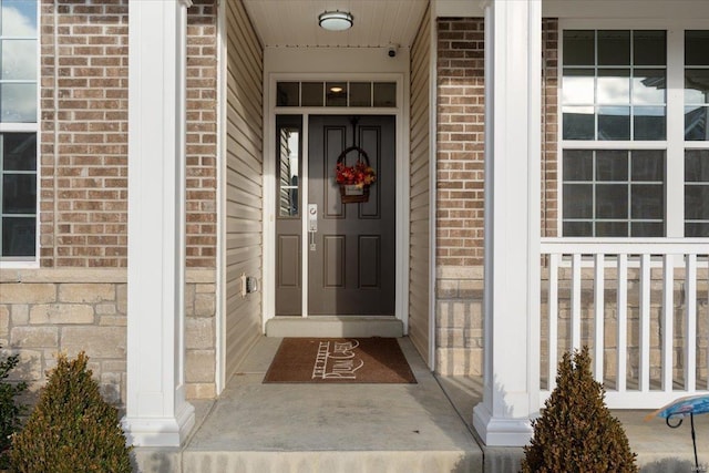 view of exterior entry featuring brick siding