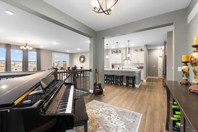 interior space with visible vents, baseboards, a chandelier, light wood-type flooring, and recessed lighting