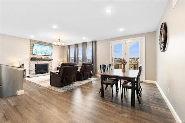 dining area featuring baseboards, recessed lighting, a fireplace, an inviting chandelier, and dark wood-style floors