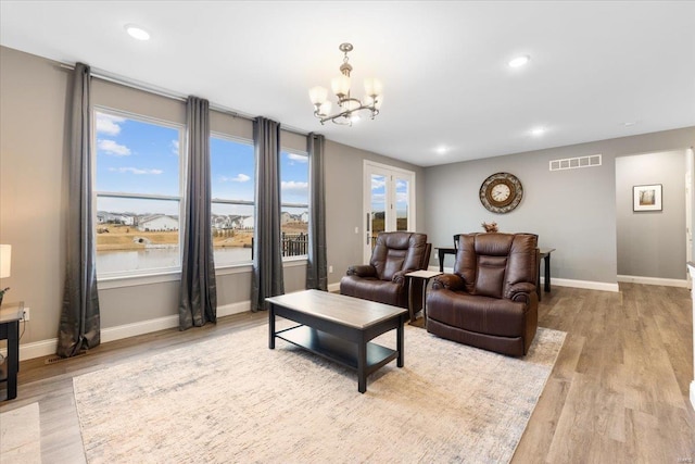 living room with recessed lighting, visible vents, light wood-style flooring, and baseboards