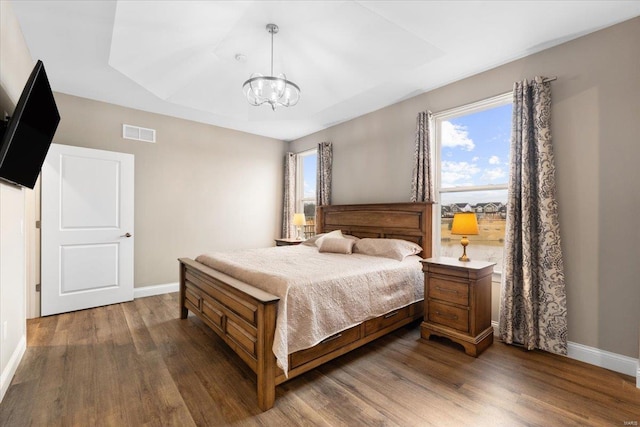 bedroom featuring visible vents, multiple windows, dark wood-type flooring, and baseboards