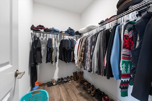 walk in closet with wood finished floors