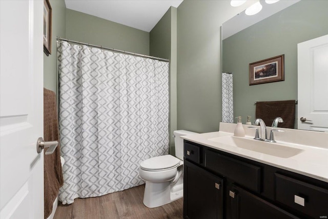 full bathroom with a shower with shower curtain, toilet, wood finished floors, and vanity