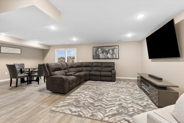 living area featuring recessed lighting, baseboards, and light wood finished floors