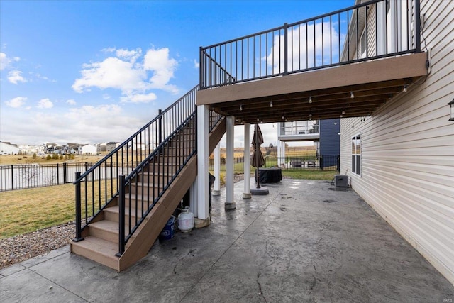 view of patio featuring stairway, fence, a water view, and central AC