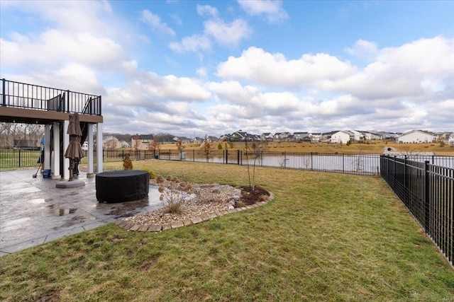 view of yard with a patio area, a fenced backyard, and a water view