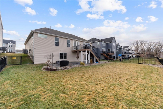 back of property featuring a wooden deck, a yard, a fenced backyard, stairs, and a residential view