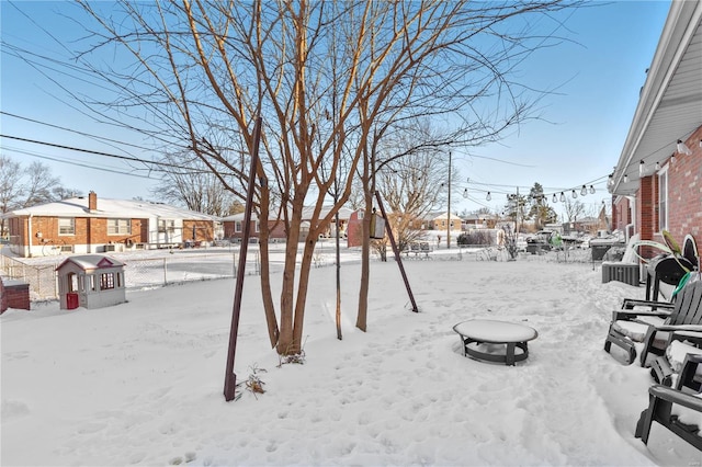 yard layered in snow with an outdoor fire pit