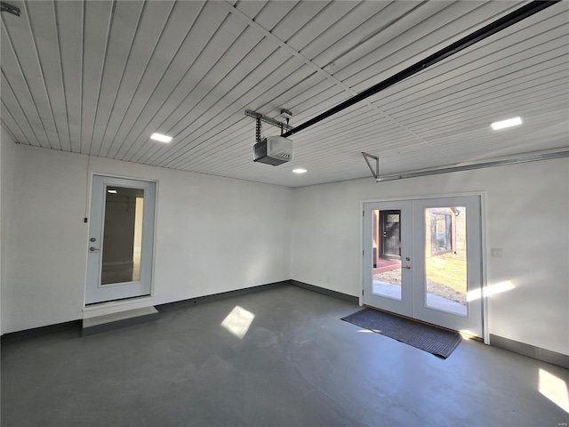 garage featuring a garage door opener, french doors, and baseboards