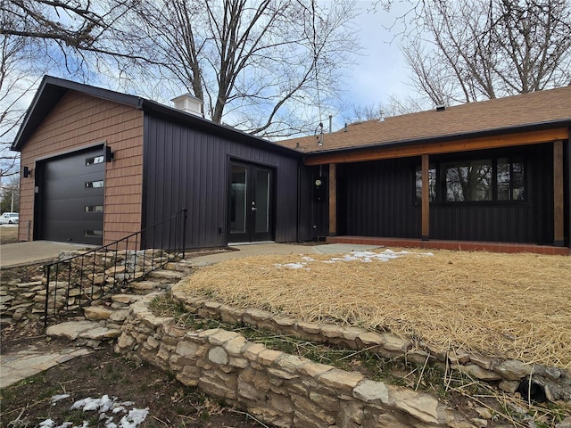 view of front facade with a garage and a chimney