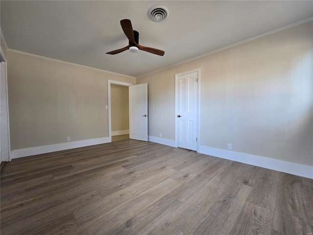 unfurnished bedroom featuring baseboards, visible vents, crown molding, and wood finished floors