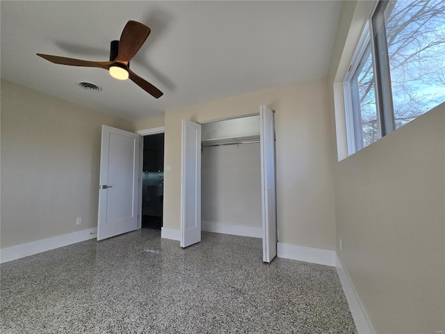 unfurnished bedroom with speckled floor, a ceiling fan, visible vents, baseboards, and a closet