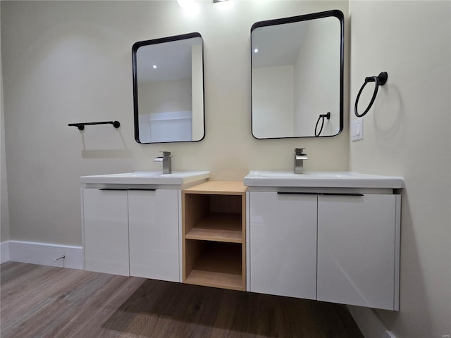 full bathroom featuring a sink, two vanities, and wood finished floors