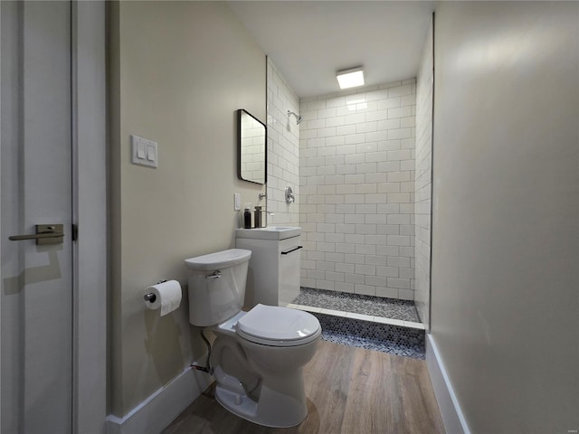 full bath featuring a stall shower, baseboards, toilet, and wood finished floors