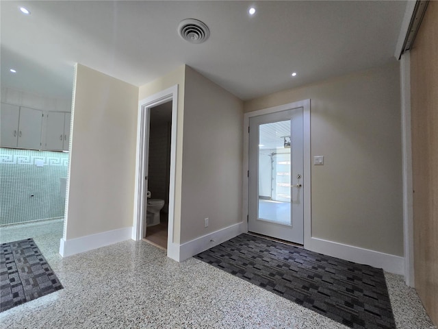 doorway featuring baseboards, visible vents, and recessed lighting