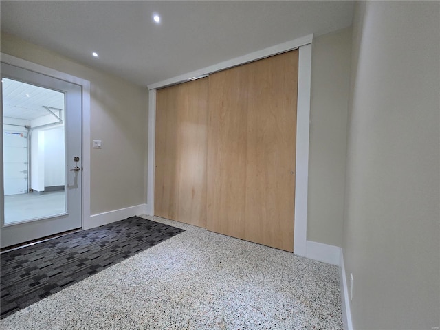 entryway with baseboards, dark speckled floor, and recessed lighting